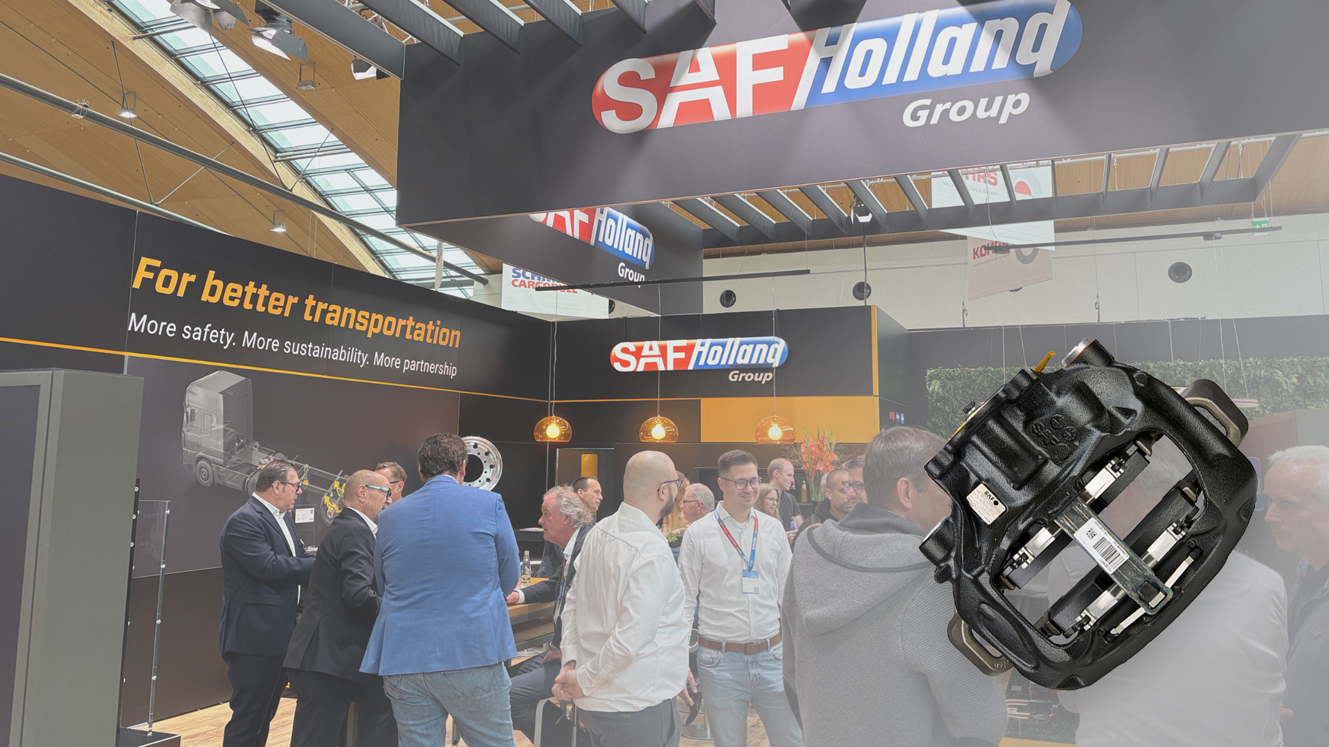 SAF-HOLLAND exhibition booth with people discussing, featuring a chassis component display.